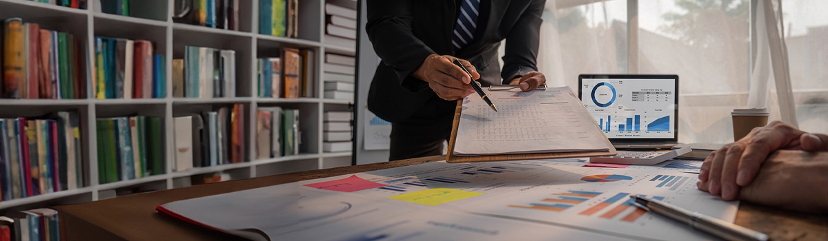 Man pointing to document with pen in meeting room